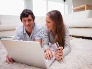 Young couple lying on the floor shopping online