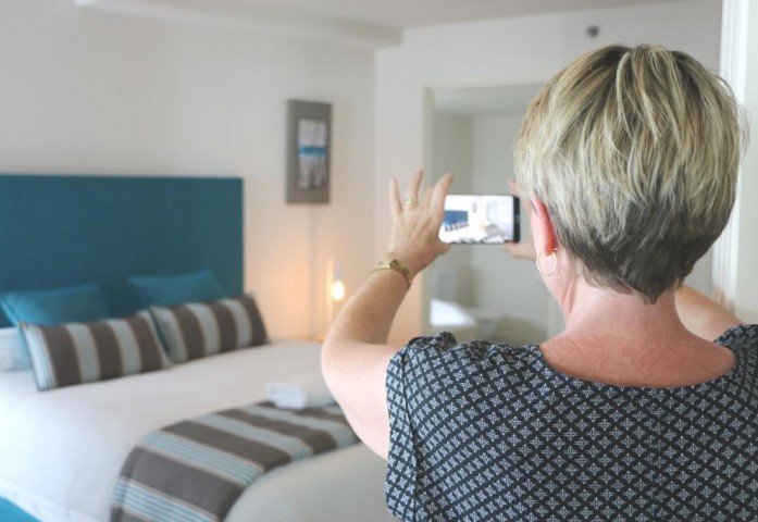 woman taking photo of hotel room on phone