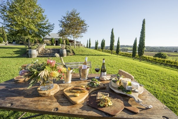 wooden table set with wine and platters outside